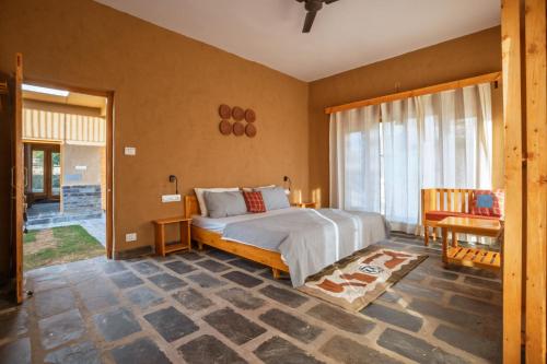 een slaapkamer met een bed en een groot raam bij The Winter Courtyard by AVVAs Stays in Bir