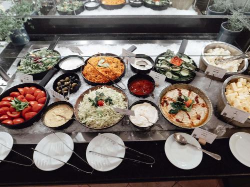 um monte de diferentes tipos de comida em uma mesa em Pullman Bucharest World Trade Center em Bucareste