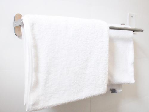 a white towel hanging on a towel rack in a bathroom at Villas at Auxilio Mutuo 102 in San Juan