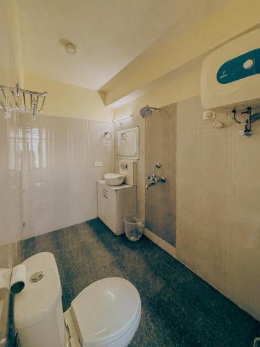 a bathroom with a white toilet and a shower at Casa Tranquila in Gangtok