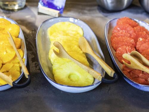 three trays of fruit with wooden spoons in them at Mercure Townsville in Townsville