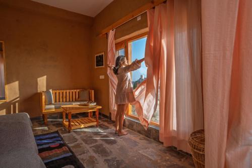 een vrouw springt uit een raam bij The Winter Courtyard by AVVAs Stays in Bir