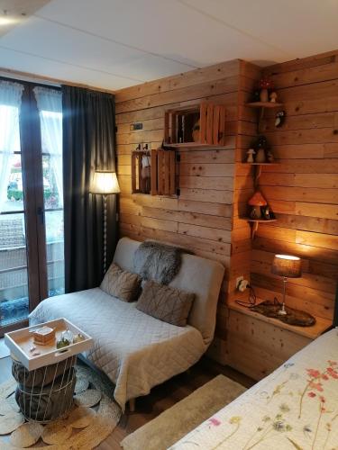 a bedroom with a bed and a table in a room at Au Coin Fleuri in Malmedy
