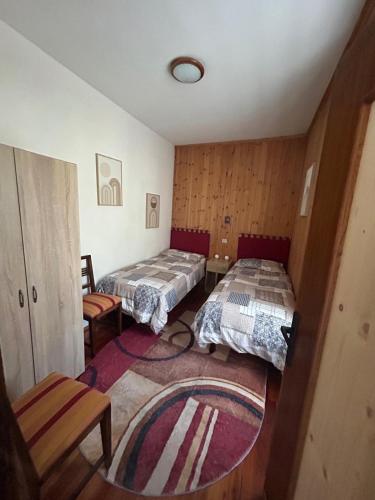 a small room with two beds and a rug at Casa Rita in Bormio