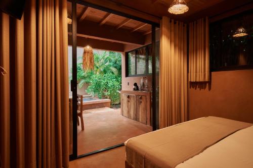 a bedroom with a bed and a door to a patio at Punta Navi - Adults only - Boutique hotel in Puerto Escondido