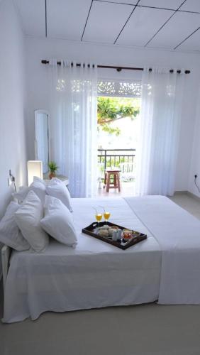 a white bed with a tray of food on it at Ananthaya- the infinity in Wadduwa