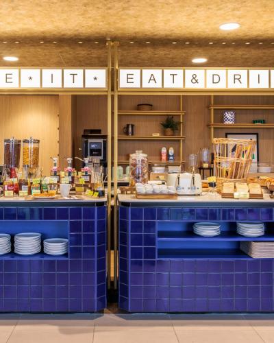 um balcão de azulejos azuis em um restaurante com pratos em Hampton By Hilton Lyon Airport em Colombier-Saugnieu