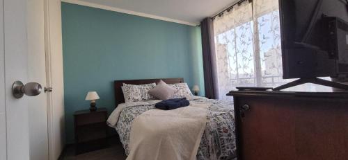 a bedroom with a bed and a tv and a window at Departamento Salar in Calama