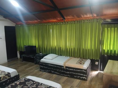 a room with two beds and a green curtain at Ella Deck Villa in Ella