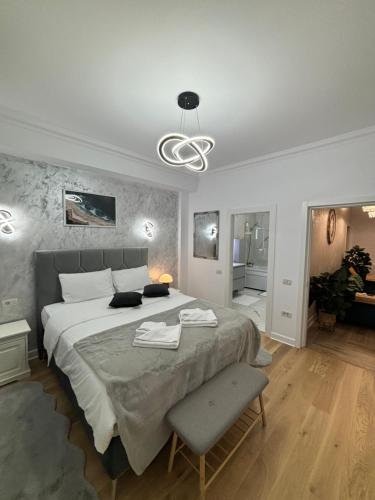 a bedroom with a large bed with a chair and a lamp at Arinis Best Bucovina Apartament in Gura Humorului