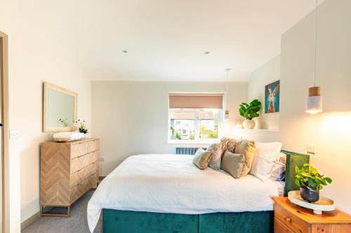 Meadow View Cottage By Leap Escapes في Caistor Saint Edmunds: غرفة نوم بسرير كبير ونافذة