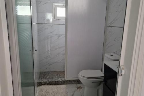a bathroom with a toilet and a glass shower at 2 Bed Villa Sleeps 4 - Garden Wifi Parking in Temara