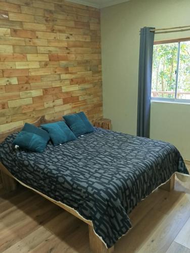 a bedroom with a bed with blue pillows at El roble cabañas in Caburgua