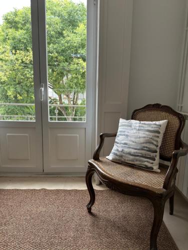 a wicker chair with a pillow in front of a door at Casa de S Bento in Santarém