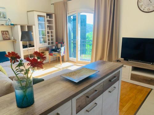 a living room with a vase with flowers on a table at Iris Lucici Aparts in Herceg-Novi