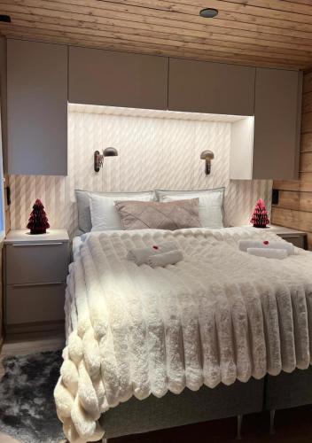 a bedroom with a large white bed with two pillows at Luxury City Cottage in Rovaniemi