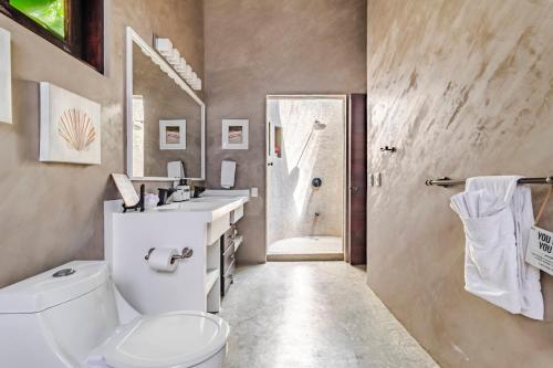 Un baño con inodoro, lavabo y ducha. en VIP La Lora Beach Villa best family home, en Santa Teresa Beach