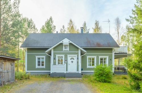 a green house with a heart on the door at Villa Metsola in Kalajoki