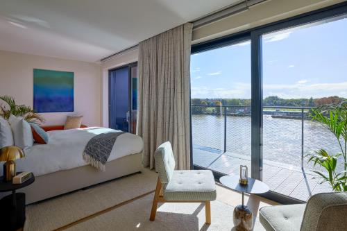 a bedroom with a bed and a large window at Fulham Pier Hotel in London