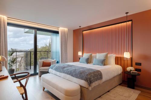 a bedroom with a large bed and a balcony at Fulham Pier Hotel in London