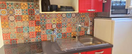 a kitchen with a sink and a tiled wall at Cœur de Provence in Marignane