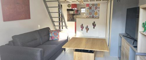 a living room with a couch and a wooden table at Cœur de Provence in Marignane