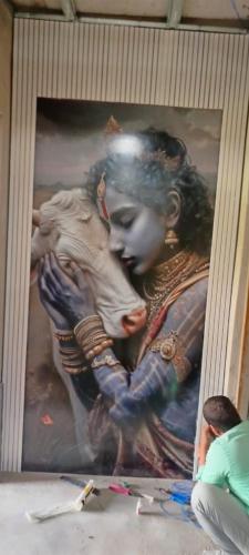 a painting of a woman holding a child at Vashishtha Rooms in Chhatikara