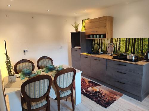 cocina con mesa, sillas y barra en Monteur Ferienwohnungen Auetal, en Bad Bodenteich