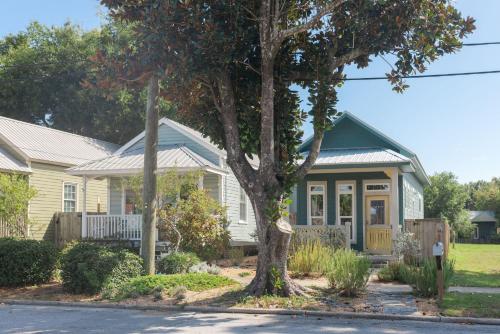 ein Haus mit einem Baum davor in der Unterkunft Sunflower Cottage Downtown in Baptist Hospital Heliport