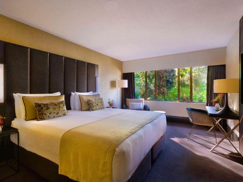 a hotel room with a large bed and a large window at Mövenpick Hotel Wellington in Wellington