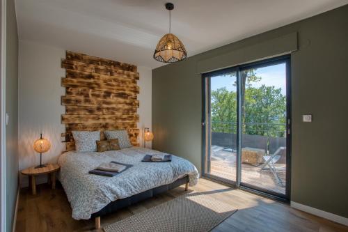 a bedroom with a bed and a large window at Le Pech Eternel - Lodge in Sarlat-la-Canéda