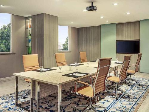 ein Konferenzraum mit einem großen Tisch und Stühlen in der Unterkunft Mercure Jakarta Kota in Jakarta