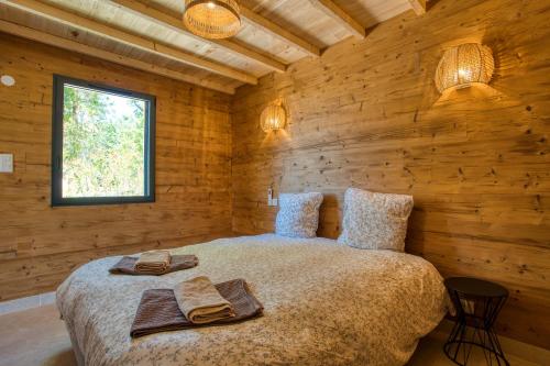 a bedroom with a bed in a wooden cabin at Le Pech Eternel - Lodge Spa Cedres in Sarlat-la-Canéda