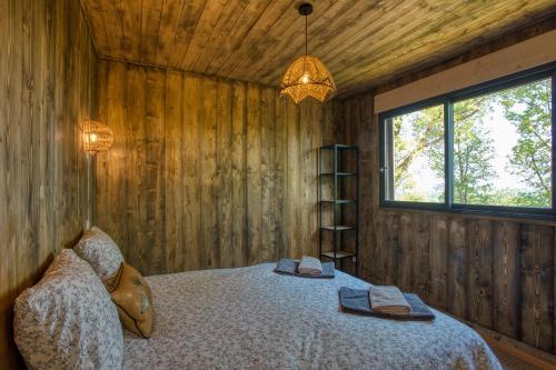 a bedroom with a bed in a wooden wall at Le Pech Eternel - Spa des Chenes in Sarlat-la-Canéda