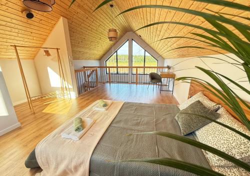 a room with a bed in the middle of a room at Stodoła HowSmart in Grady Szlacheckie