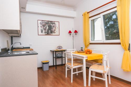 a kitchen with a table and chairs in a kitchen at Alojamento Da Cunha in Chaves