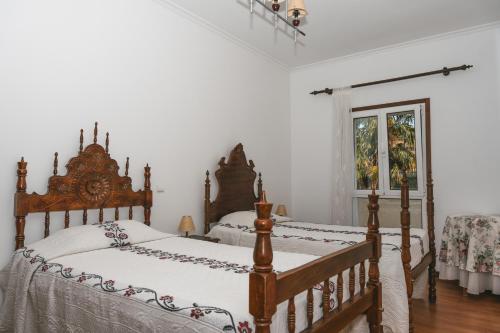 two beds in a bedroom with white walls at Alojamento Da Cunha in Chaves