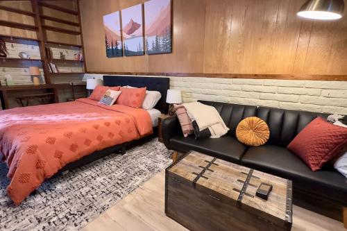 Pine Ridge Retreat في Tahoe Village: غرفة نوم مع سرير وأريكة جلدية سوداء