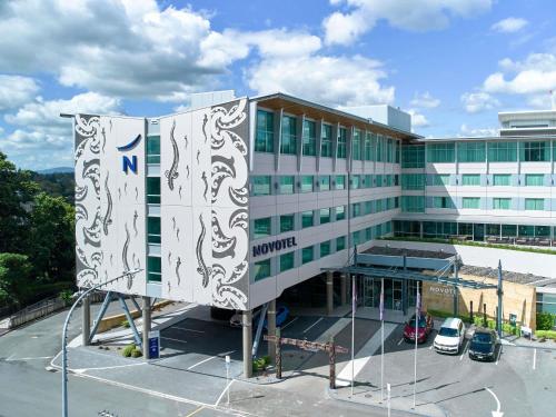 a building with a sign in front of it at Novotel Tainui Hamilton in Hamilton