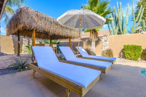 three lounge chairs and an umbrella on a patio at Boho 4BR Retreat with Heated Pool, Spa and Tiki Bar in Gilbert