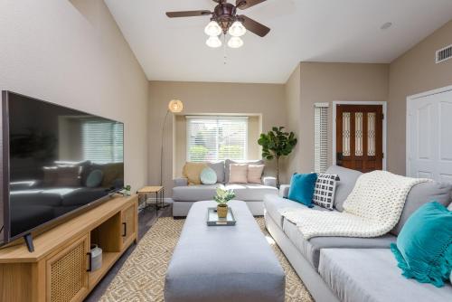 a living room with a couch and a flat screen tv at Boho 4BR Retreat with Heated Pool, Spa and Tiki Bar in Gilbert