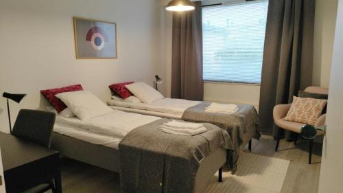 a small room with two beds and a window at Spacious Apartment for 6 with Sauna in Kemi