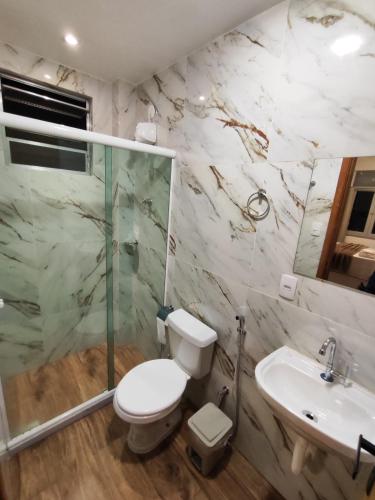 a bathroom with a toilet and a shower and a sink at Loft 318 Ar Cond Wi-fi TV filmes e series in Niterói