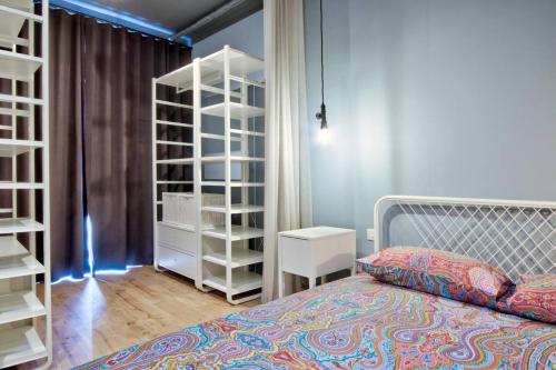 een slaapkamer met een bed en een boekenplank bij The Cove in Sliema