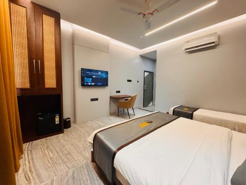 a hotel room with a bed and a desk at Hotel Mumbai House Pithampur in Dhār