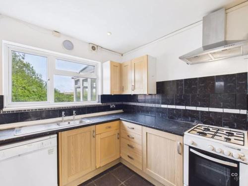 a kitchen with a sink and a stove top oven at Spacious 5 BR Brighton Home with Parking in Brighton & Hove