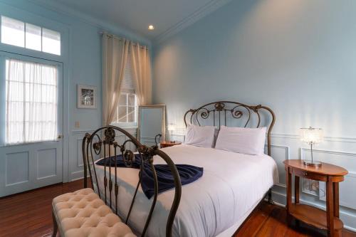 ein Schlafzimmer mit einem Bett mit weißen Laken und blauen Wänden in der Unterkunft 5 New Orleans Themed Units in FQ with Pool in New Orleans