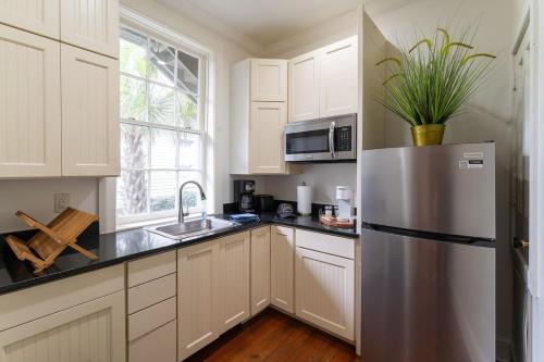 eine Küche mit weißen Schränken und einem Edelstahlkühlschrank in der Unterkunft 5 New Orleans Themed Units in FQ with Pool in New Orleans