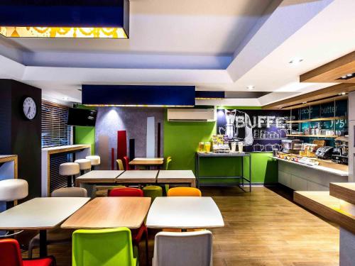 a restaurant with tables and chairs and a kitchen at ibis Budget - Enfield in Sydney