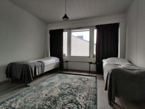 a bedroom with two beds and a window at Central and Spacious Apartment for 11 in Kemi